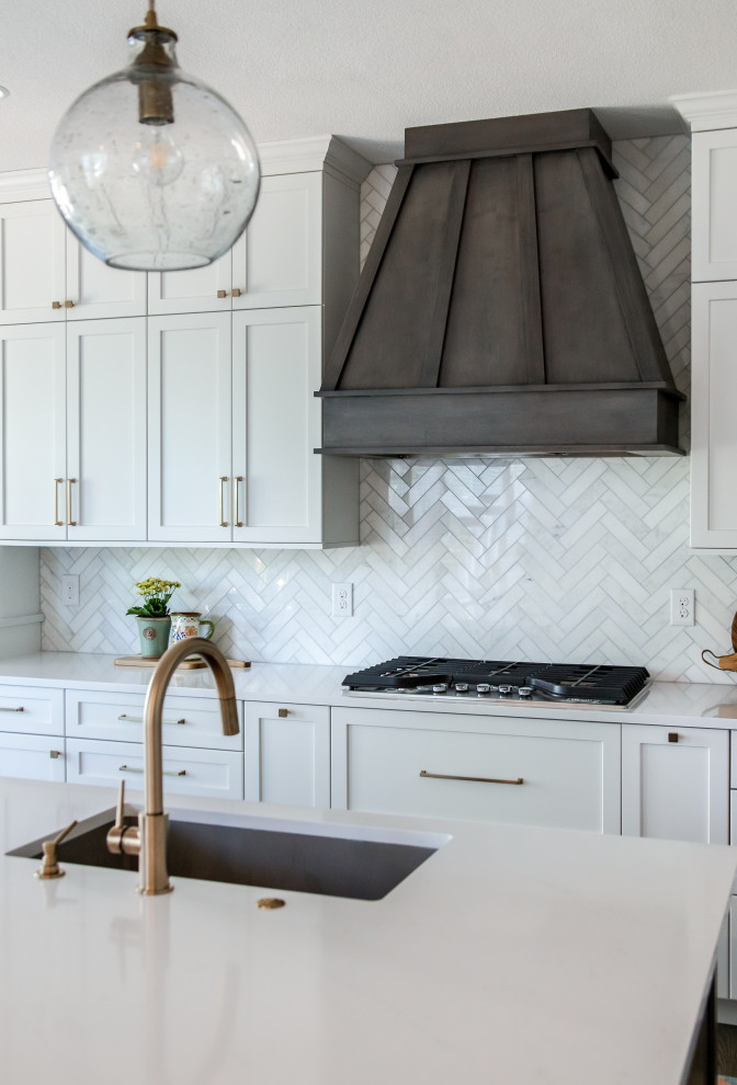 Open concept kitchen - large transitional galley medium tone wood floor and brown floor open concept kitchen idea in Denver with an undermount sink, shaker cabinets, white cabinets, quartz countertops, beige backsplash, marble backsplash, stainless steel appliances, an island and white countertops