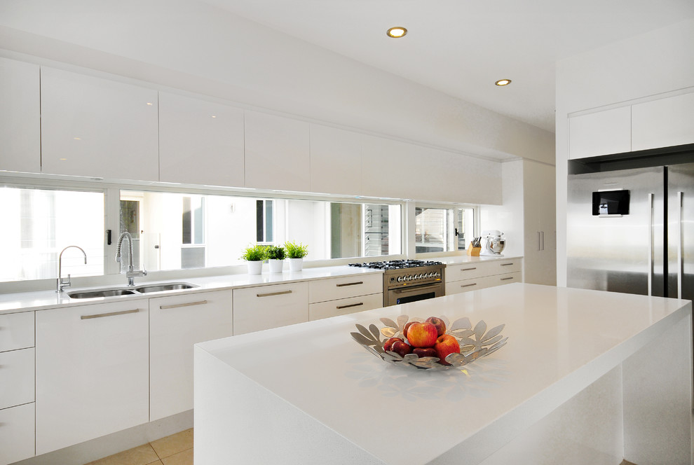 Moderne Küche in L-Form mit Doppelwaschbecken, flächenbündigen Schrankfronten, weißen Schränken und Kücheninsel in Brisbane