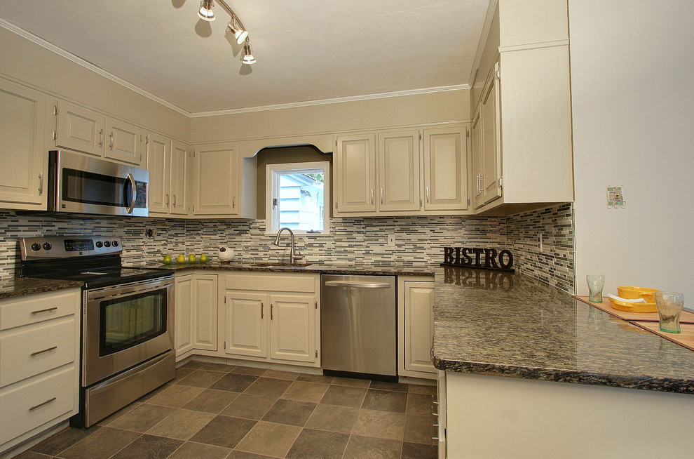 Example of a mid-sized minimalist u-shaped porcelain tile enclosed kitchen design in New York with an undermount sink, raised-panel cabinets, gray cabinets, granite countertops, gray backsplash, glass tile backsplash, stainless steel appliances and no island