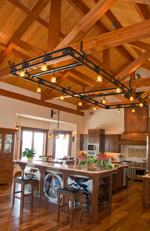 Offene Klassische Küche mit dunklen Holzschränken, Küchenrückwand in Beige, Rückwand aus Steinfliesen, braunem Holzboden, Kücheninsel und Granit-Arbeitsplatte in Austin