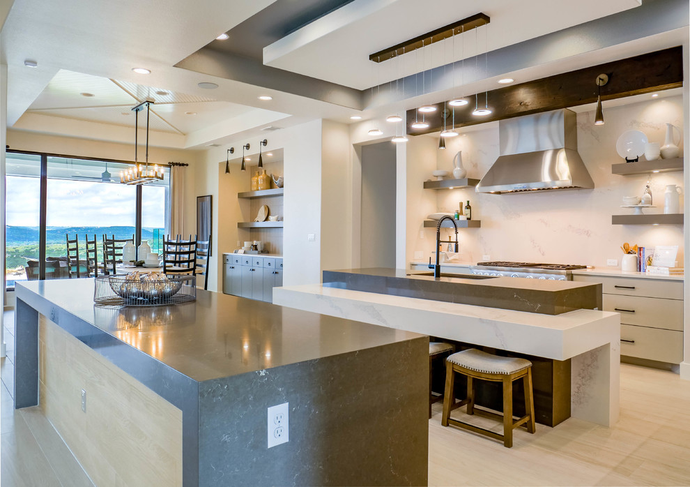 Einzeilige, Geräumige Moderne Wohnküche mit Landhausspüle, Quarzwerkstein-Arbeitsplatte, Küchenrückwand in Weiß, schwarzen Elektrogeräten, hellem Holzboden und zwei Kücheninseln in Austin