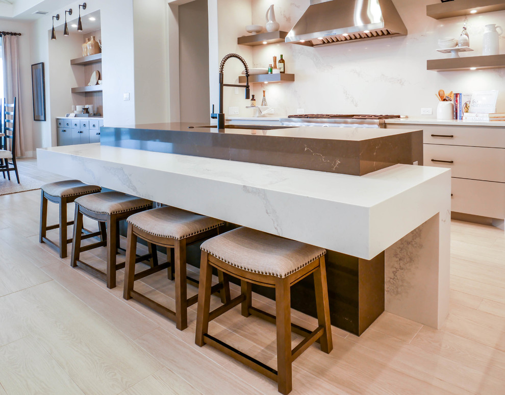 Eat-in kitchen - huge contemporary single-wall light wood floor eat-in kitchen idea in Austin with a farmhouse sink, quartz countertops, white backsplash, black appliances and two islands