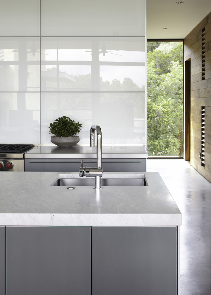 Réalisation d'une cuisine grise et blanche design avec des portes de placard grises.