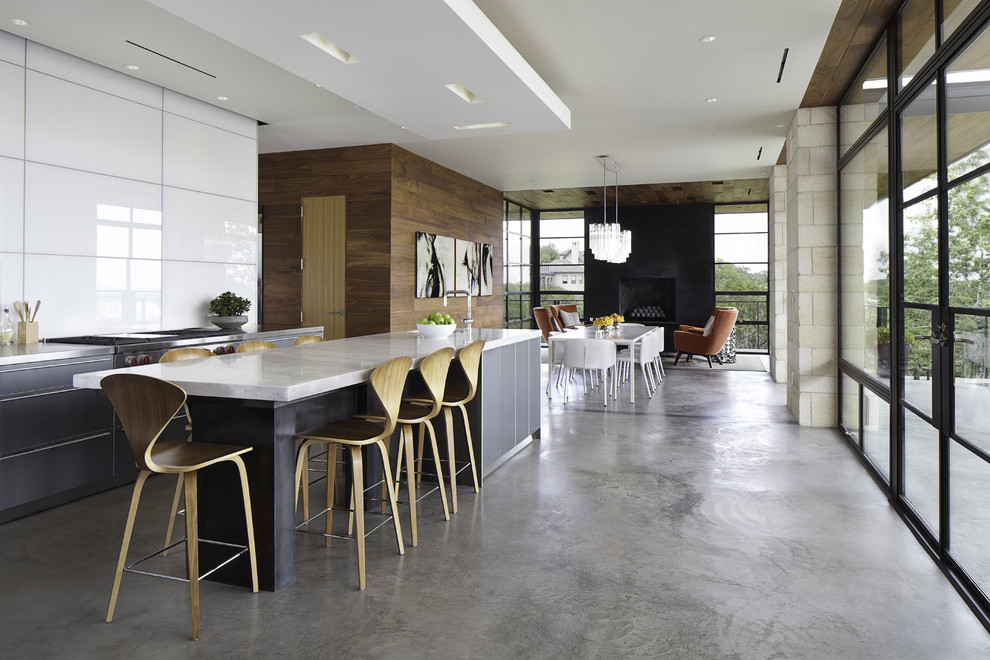 Идея дизайна: параллельная кухня-гостиная в стиле модернизм с плоскими фасадами, серыми фасадами, белым фартуком и техникой из нержавеющей стали