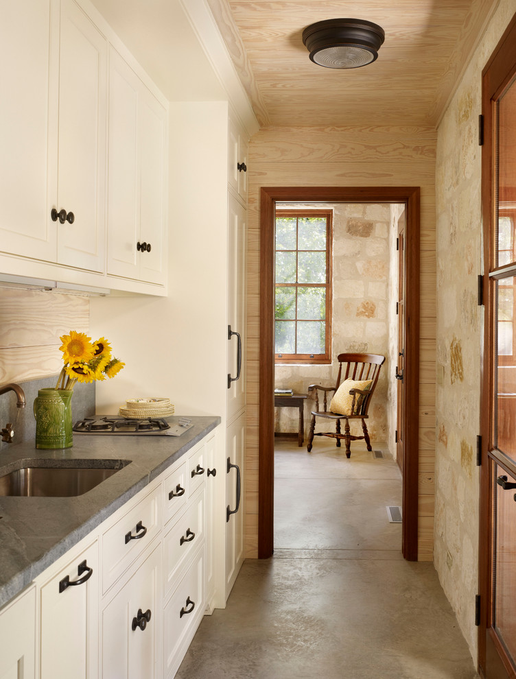 Cette photo montre une cuisine nature avec un placard avec porte à panneau encastré et des portes de placard blanches.