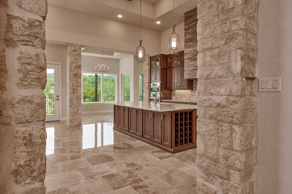 Exempel på ett mellanstort klassiskt beige beige kök och matrum, med en undermonterad diskho, luckor med infälld panel, bruna skåp, träbänkskiva, beige stänkskydd, stänkskydd i marmor, rostfria vitvaror, marmorgolv, en köksö och beiget golv