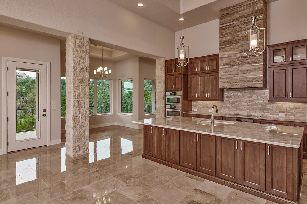 Mid-sized transitional marble floor and beige floor eat-in kitchen photo in Austin with an undermount sink, recessed-panel cabinets, brown cabinets, wood countertops, beige backsplash, marble backsplash, stainless steel appliances, an island and beige countertops