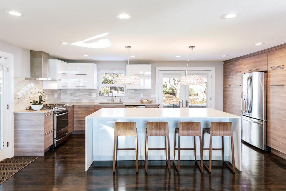 Mid-sized trendy u-shaped dark wood floor open concept kitchen photo in Salt Lake City with a drop-in sink, flat-panel cabinets, medium tone wood cabinets, solid surface countertops, multicolored backsplash, ceramic backsplash, stainless steel appliances and an island