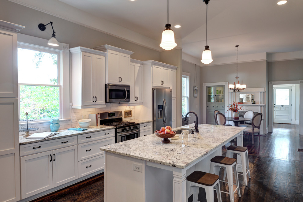 Example of a mid-sized classic galley dark wood floor eat-in kitchen design in Atlanta with an undermount sink, shaker cabinets, dark wood cabinets, granite countertops, white backsplash, ceramic backsplash, stainless steel appliances and an island