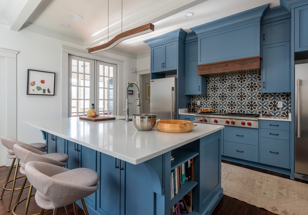 This is an example of a medium sized classic galley kitchen/diner in Atlanta with flat-panel cabinets, blue cabinets, composite countertops, multi-coloured splashback, ceramic splashback, stainless steel appliances, an island, brown floors, white worktops, a single-bowl sink and dark hardwood flooring.