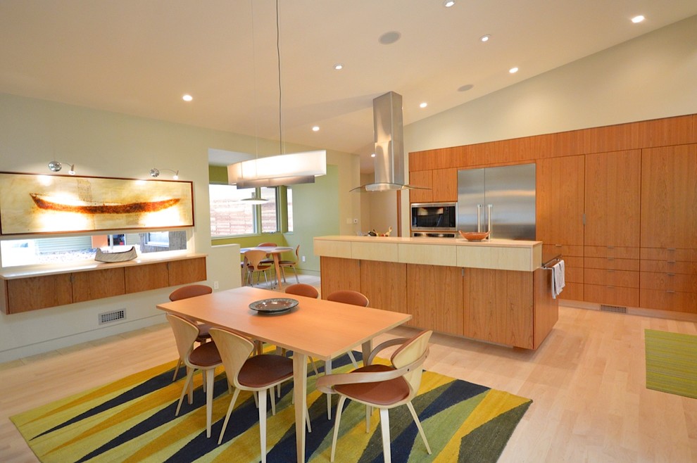 Moderne Wohnküche mit flächenbündigen Schrankfronten, hellbraunen Holzschränken, Quarzwerkstein-Arbeitsplatte und hellem Holzboden in Raleigh