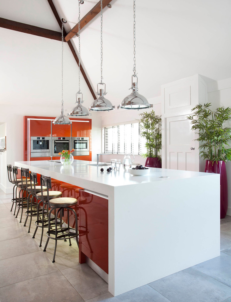 Inredning av ett modernt avskilt, stort linjärt kök, med släta luckor, orange skåp, bänkskiva i koppar, vitt stänkskydd, rostfria vitvaror, klinkergolv i keramik, en köksö och grått golv
