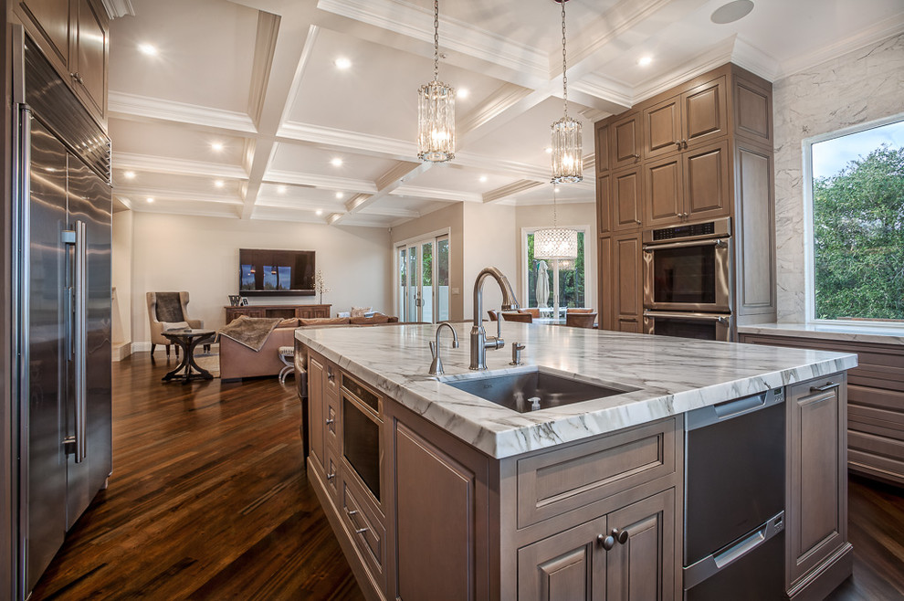 Expansive traditional u-shaped open plan kitchen in San Francisco with a submerged sink, beaded cabinets, medium wood cabinets, marble worktops, stone tiled splashback, stainless steel appliances, dark hardwood flooring and an island.