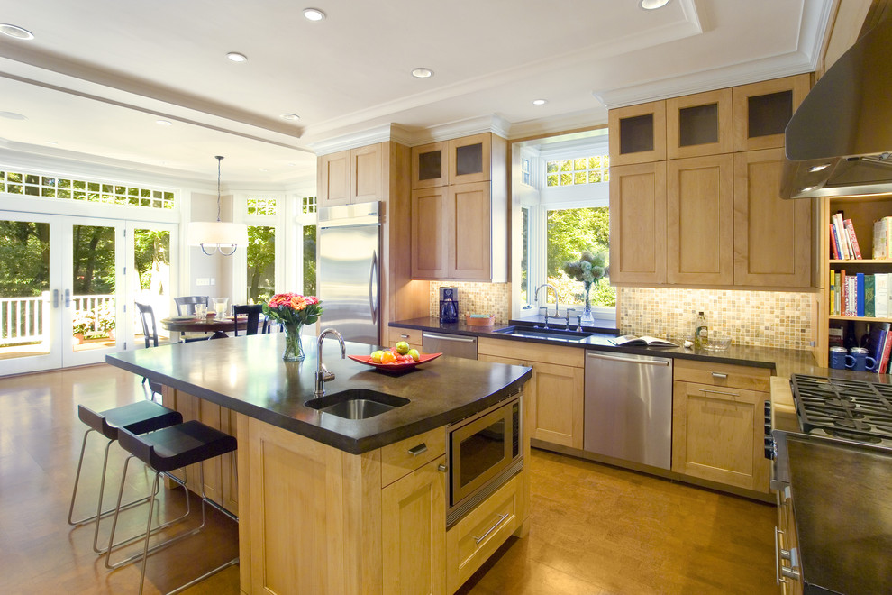 Bild på ett mellanstort funkis kök, med en undermonterad diskho, luckor med infälld panel, skåp i ljust trä, beige stänkskydd, stänkskydd i mosaik, rostfria vitvaror, mellanmörkt trägolv, en köksö och brunt golv
