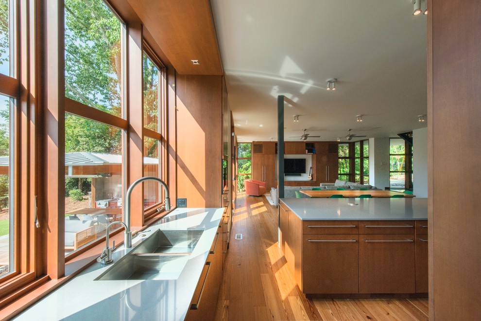 Esempio di una cucina moderna di medie dimensioni con lavello a doppia vasca, ante lisce, ante in legno scuro, top in superficie solida, pavimento in legno massello medio, pavimento marrone e top grigio