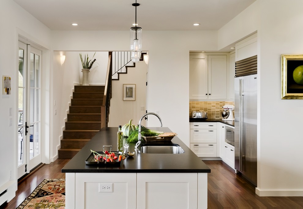 Inspiration for a contemporary kitchen remodel in Burlington with stainless steel appliances, an undermount sink, shaker cabinets, white cabinets, soapstone countertops and multicolored backsplash