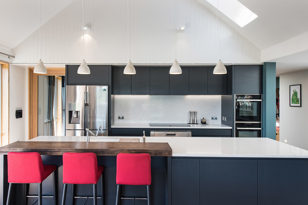 На фото: параллельная кухня в современном стиле с плоскими фасадами, синими фасадами, белым фартуком, техникой из нержавеющей стали и островом