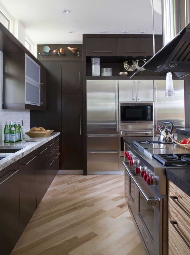 Geschlossene Moderne Küche mit Küchengeräten aus Edelstahl, flächenbündigen Schrankfronten und dunklen Holzschränken in Denver
