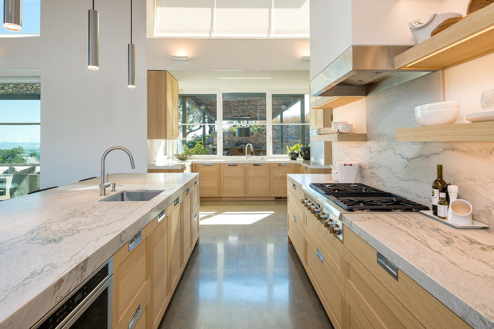 Traditional u-shaped open plan kitchen in San Francisco with a submerged sink, shaker cabinets, light wood cabinets, grey splashback, an island, grey floors and grey worktops.
