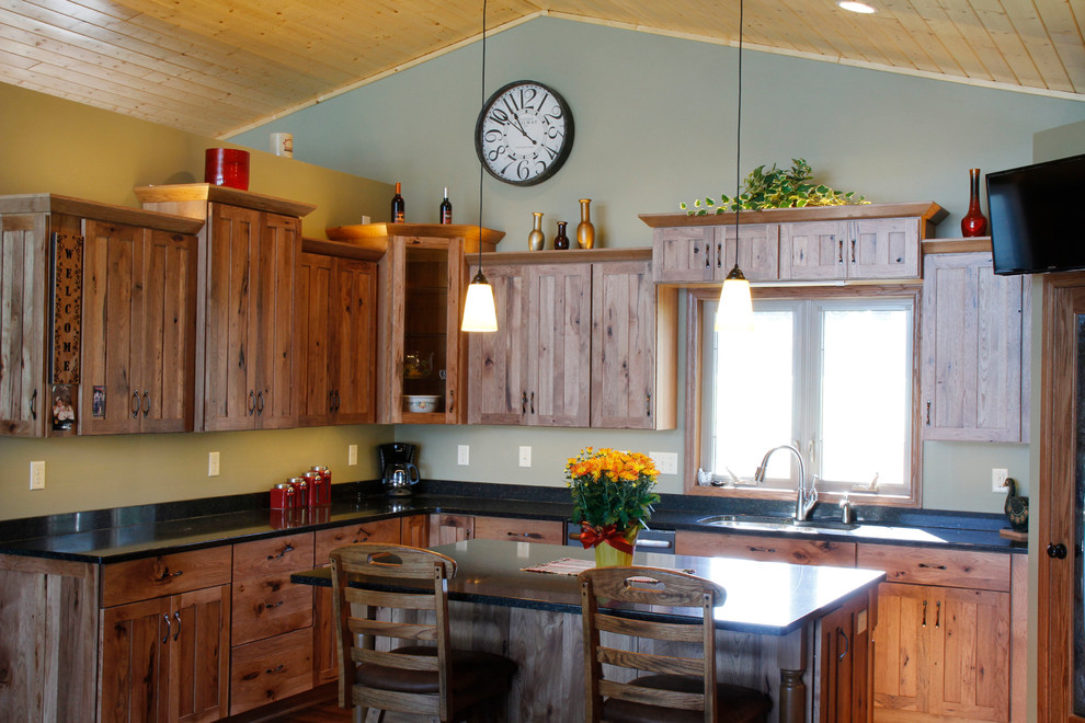 Kitchen - mid-sized rustic u-shaped medium tone wood floor and brown floor kitchen idea in Minneapolis with an undermount sink, shaker cabinets, medium tone wood cabinets, quartz countertops, stainless steel appliances, an island and black countertops