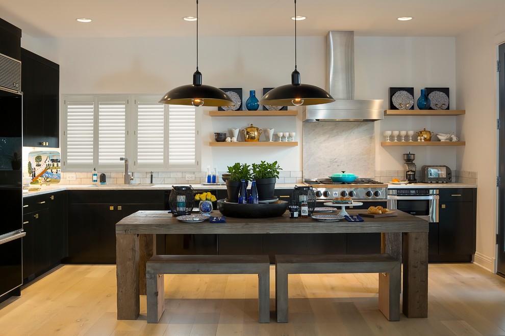 Mittelgroße Klassische Wohnküche in L-Form mit flächenbündigen Schrankfronten, schwarzen Schränken, Küchenrückwand in Weiß, Rückwand aus Stein und hellem Holzboden in Los Angeles