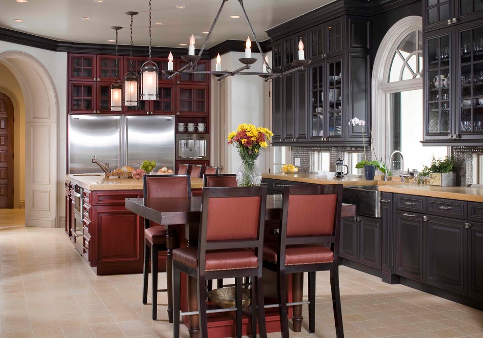 This is an example of a traditional kitchen in Denver with dark wood cabinets and metallic splashback.