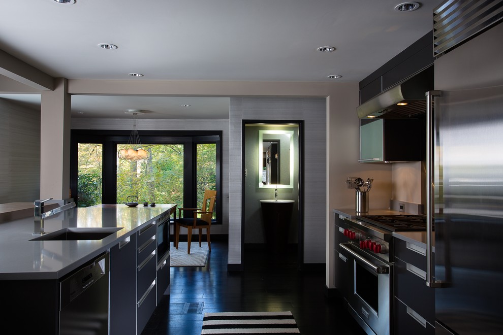 Стильный дизайн: прямая кухня-гостиная среднего размера в современном стиле с одинарной мойкой, плоскими фасадами, серыми фасадами, столешницей из кварцевого агломерата, техникой из нержавеющей стали, темным паркетным полом и островом - последний тренд