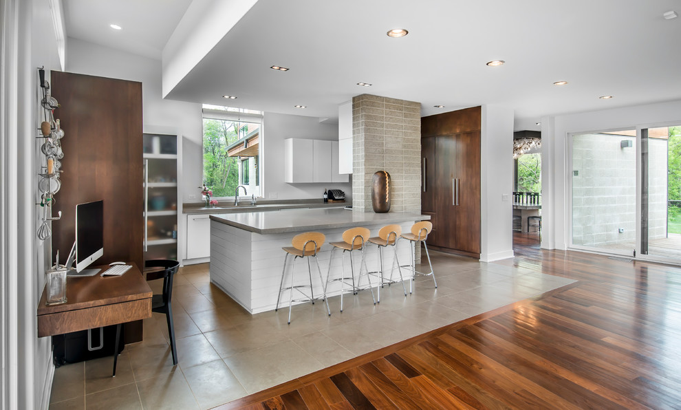 Example of a mid-sized minimalist u-shaped limestone floor and beige floor open concept kitchen design in Other with an undermount sink, flat-panel cabinets, white cabinets, stainless steel appliances, an island and granite countertops