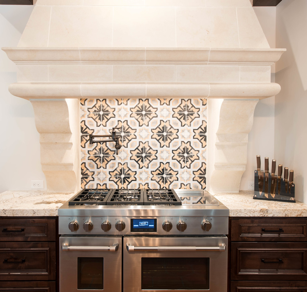 Inredning av ett medelhavsstil stort kök, med luckor med upphöjd panel, skåp i mörkt trä, granitbänkskiva, flerfärgad stänkskydd, stänkskydd i mosaik, rostfria vitvaror och en köksö