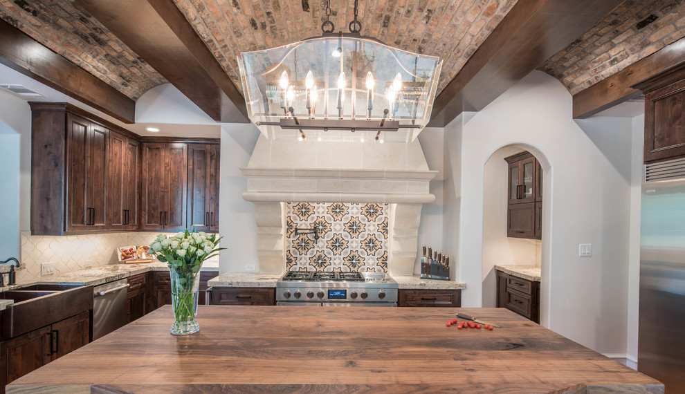 Large tuscan u-shaped terra-cotta tile and orange floor open concept kitchen photo in Houston with a farmhouse sink, raised-panel cabinets, dark wood cabinets, granite countertops, multicolored backsplash, mosaic tile backsplash, stainless steel appliances and an island
