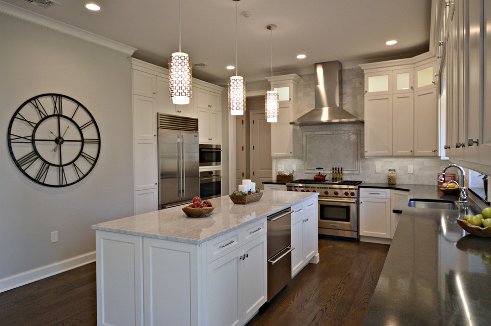 Example of a large transitional l-shaped dark wood floor eat-in kitchen design in New York with an undermount sink, recessed-panel cabinets, white cabinets, marble countertops, gray backsplash, subway tile backsplash, stainless steel appliances and an island