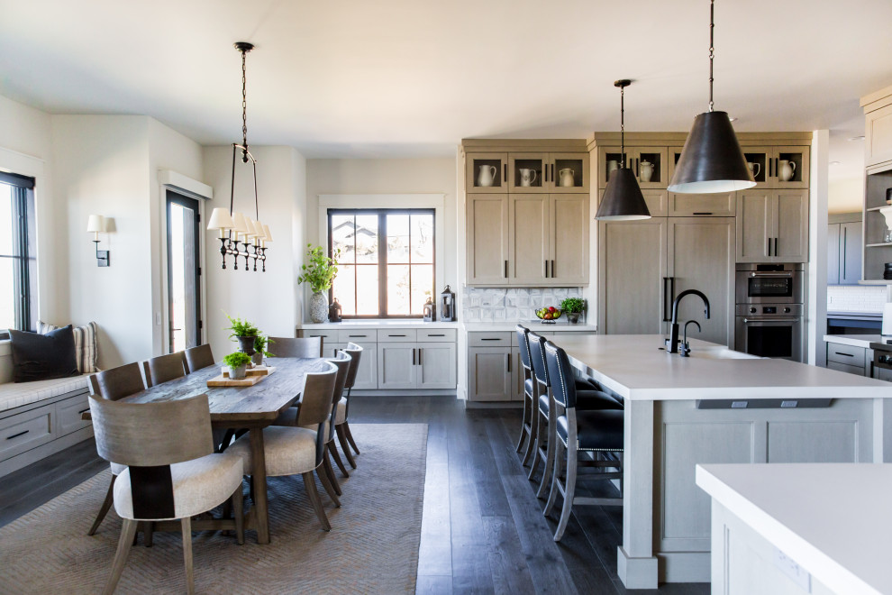 Design ideas for a large rustic single-wall kitchen/diner in Salt Lake City with shaker cabinets, beige cabinets, white splashback, stainless steel appliances, dark hardwood flooring, an island, brown floors and yellow worktops.