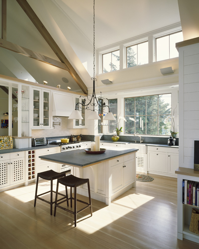 Пример оригинального дизайна: кухня в современном стиле с белыми фасадами, белым фартуком, светлым паркетным полом и островом