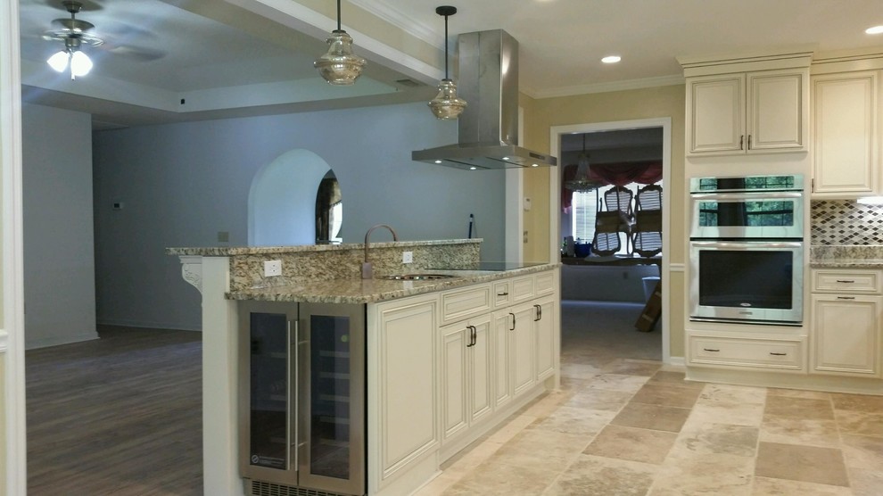 Inspiration for a mid-sized timeless l-shaped travertine floor eat-in kitchen remodel in Atlanta with a farmhouse sink, raised-panel cabinets, white cabinets, granite countertops, multicolored backsplash, glass tile backsplash, stainless steel appliances and an island