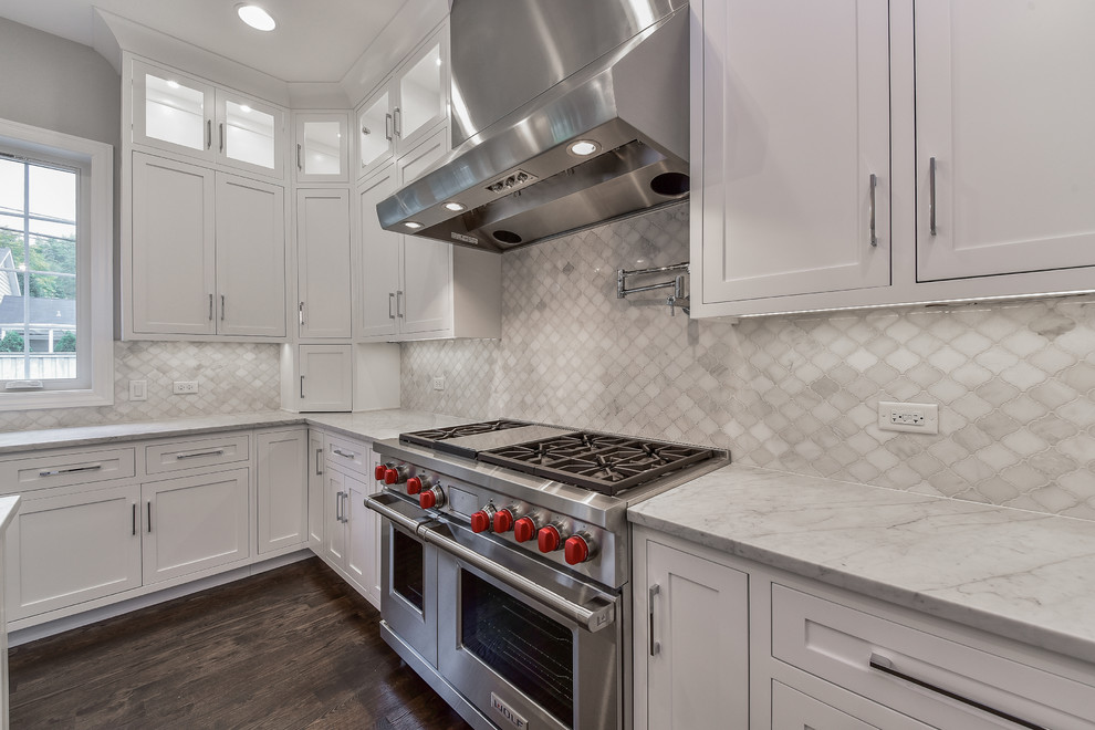 Foto på ett stort funkis grå kök med öppen planlösning, med skåp i shakerstil, vita skåp, marmorbänkskiva, grått stänkskydd, stänkskydd i marmor, rostfria vitvaror, mörkt trägolv, en köksö och brunt golv