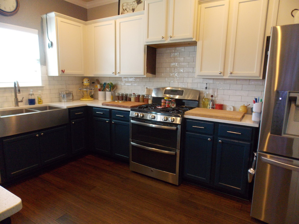 Inredning av ett lantligt mellanstort kök, med en rustik diskho, släta luckor, blå skåp, bänkskiva i kvarts, vitt stänkskydd, stänkskydd i tunnelbanekakel, rostfria vitvaror, mellanmörkt trägolv och en halv köksö