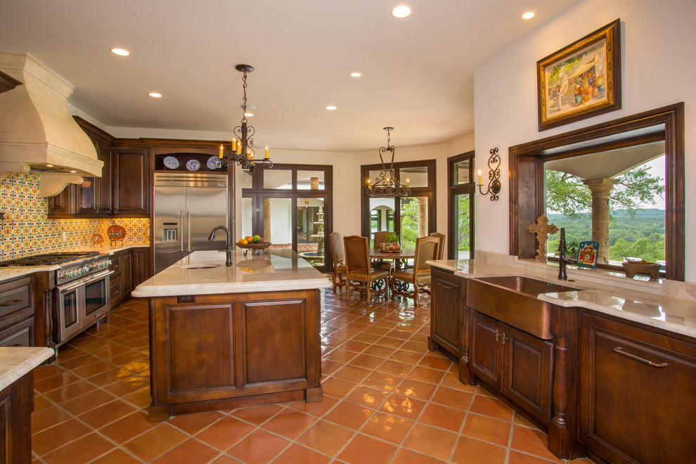 Example of a mid-sized tuscan u-shaped enclosed kitchen design in Austin with an undermount sink, raised-panel cabinets, dark wood cabinets, granite countertops, yellow backsplash, ceramic backsplash, stainless steel appliances and an island