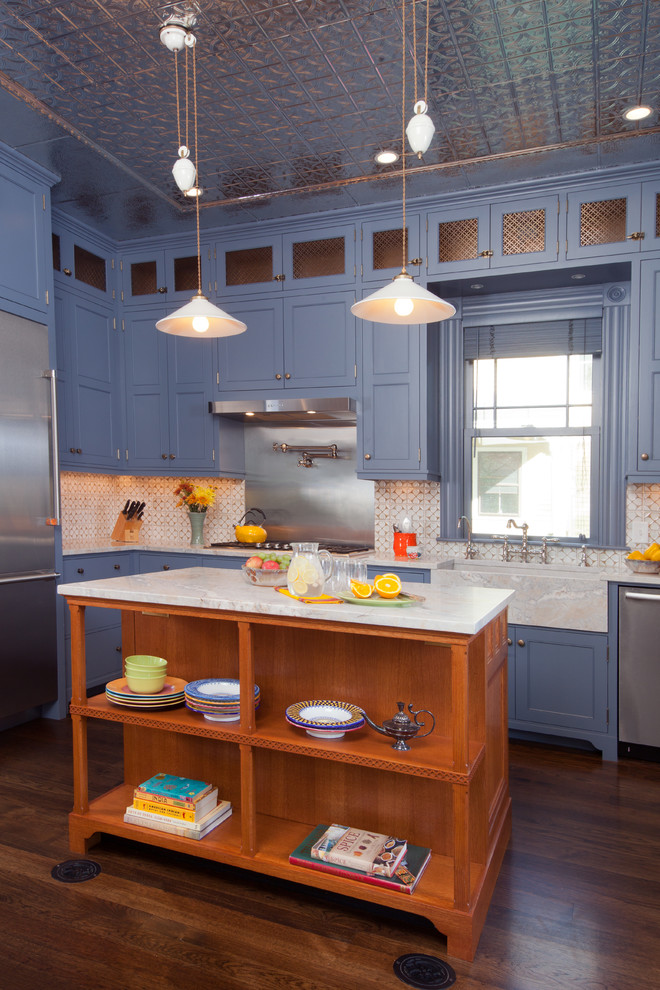 Idéer för mellanstora vintage kök, med en rustik diskho, luckor med profilerade fronter, blå skåp, bänkskiva i kvartsit, vitt stänkskydd, stänkskydd i mosaik, rostfria vitvaror, mellanmörkt trägolv och en köksö