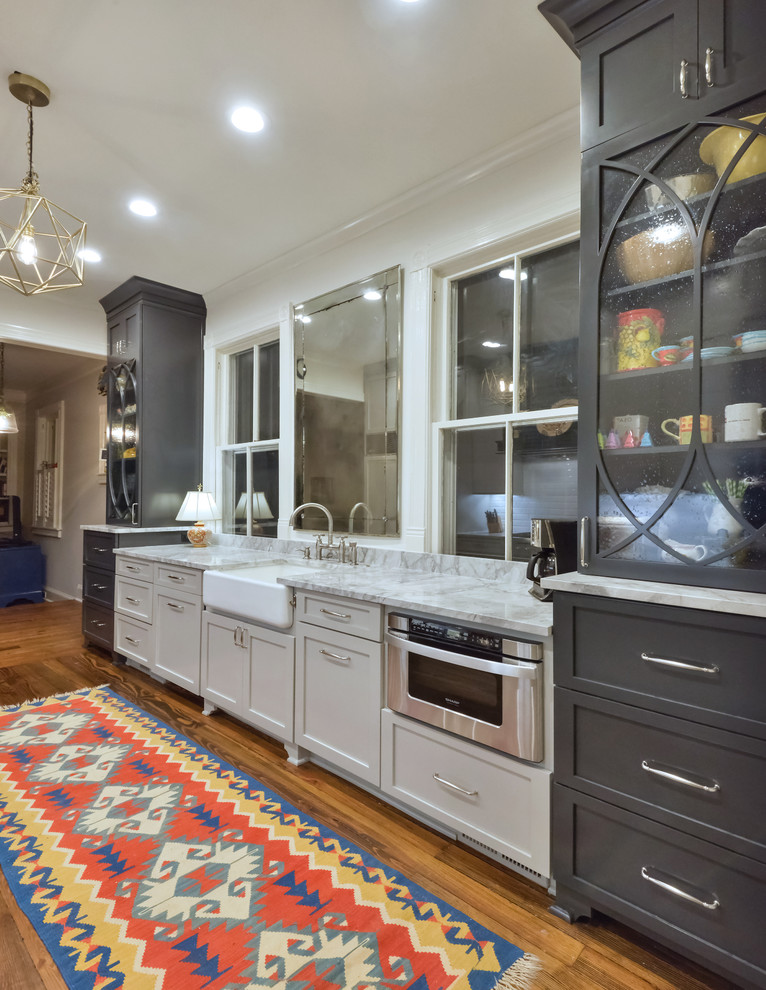 Klassische Küche mit Landhausspüle, Schrankfronten im Shaker-Stil, grauen Schränken, Küchengeräten aus Edelstahl und braunem Holzboden in Charleston