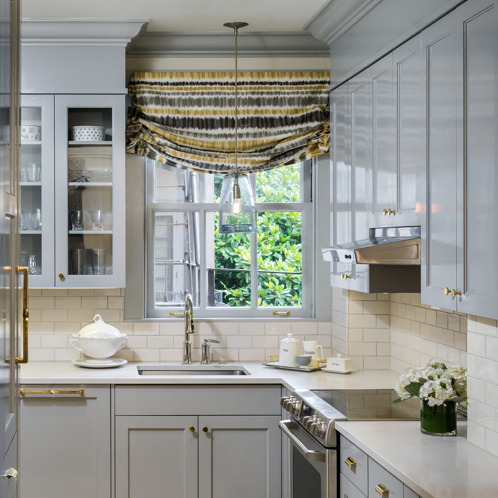 Imagen de cocina clásica renovada con fregadero bajoencimera, armarios estilo shaker, puertas de armario grises, salpicadero blanco y salpicadero de azulejos tipo metro