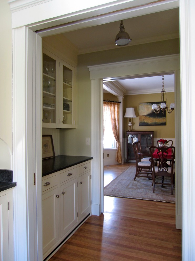 ボストンにある高級な小さなエクレクティックスタイルのおしゃれなキッチン (シェーカースタイル扉のキャビネット、白いキャビネット、御影石カウンター、白いキッチンパネル、木材のキッチンパネル、淡色無垢フローリング、アイランドなし) の写真