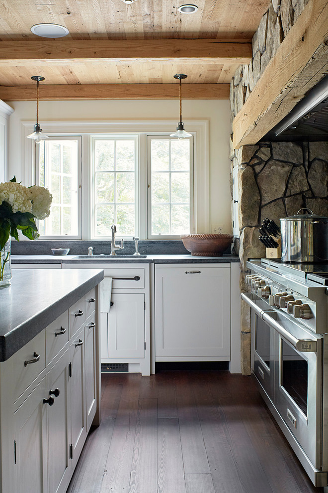 Foto di una cucina country con lavello da incasso, ante a filo, ante bianche, top in cemento, elettrodomestici in acciaio inossidabile e parquet scuro