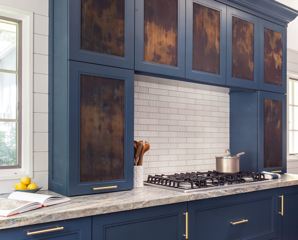 Inspiration för stora klassiska grått kök, med en undermonterad diskho, luckor med infälld panel, blå skåp, granitbänkskiva, vitt stänkskydd, stänkskydd i tunnelbanekakel, integrerade vitvaror, cementgolv, en köksö och svart golv