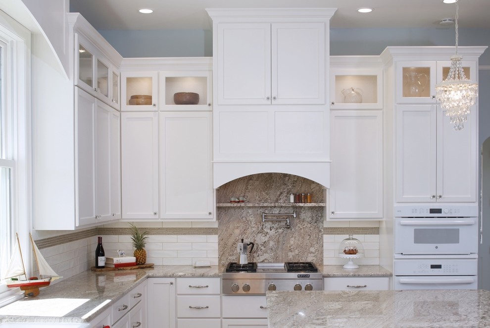 Exempel på ett mycket stort klassiskt kök och matrum, med en rustik diskho, luckor med infälld panel, vita skåp, marmorbänkskiva, vitt stänkskydd, stänkskydd i tunnelbanekakel, vita vitvaror, mellanmörkt trägolv och en köksö