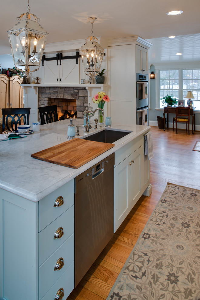 Inspiration for a timeless single-wall eat-in kitchen remodel in Detroit with an undermount sink, shaker cabinets, white cabinets, granite countertops, white backsplash, glass tile backsplash and stainless steel appliances