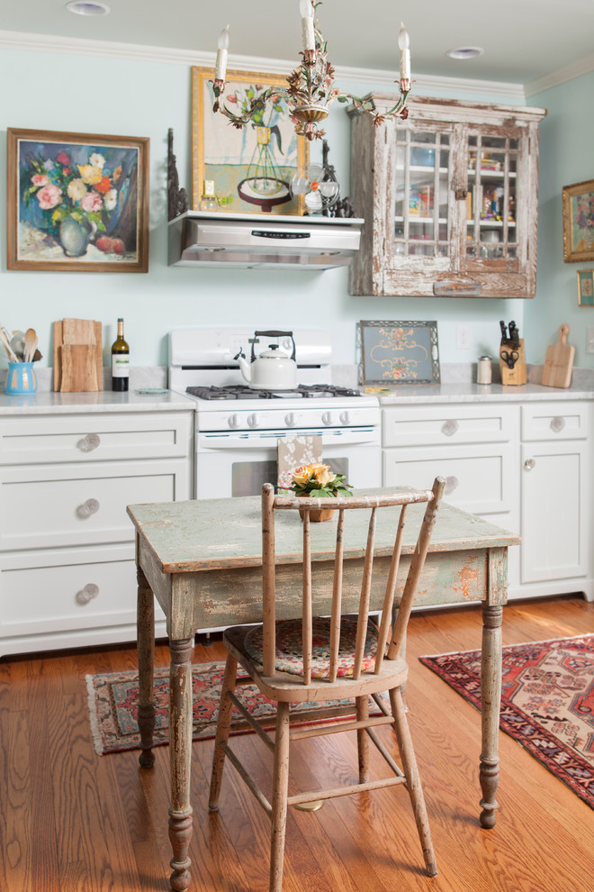 Immagine di una cucina abitabile shabby-chic style con ante con riquadro incassato, ante con finitura invecchiata, elettrodomestici bianchi e top in marmo