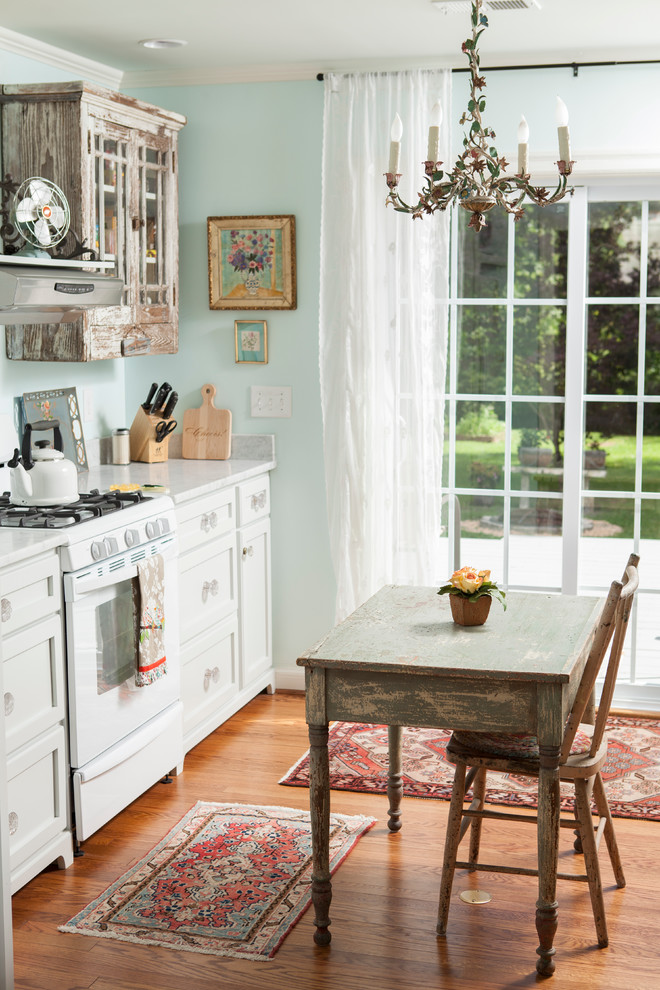 Inspiration for a shabby-chic style enclosed kitchen remodel in Wilmington with white cabinets, marble countertops, white appliances and recessed-panel cabinets