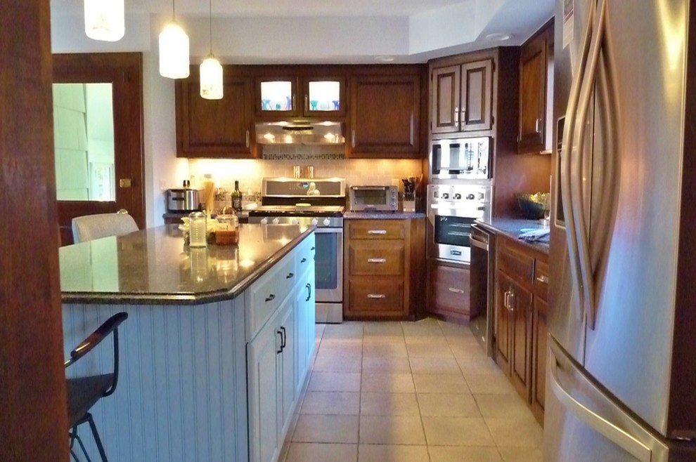 Exempel på ett mellanstort klassiskt kök, med en undermonterad diskho, luckor med upphöjd panel, skåp i mörkt trä, granitbänkskiva, stänkskydd i glaskakel, rostfria vitvaror, klinkergolv i keramik, en köksö och beige stänkskydd