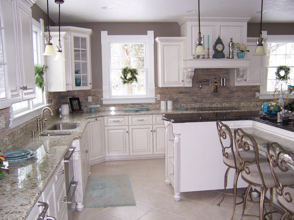 Foto di una cucina classica con lavello sottopiano, ante con bugna sagomata, ante bianche, top in granito, paraspruzzi marrone, paraspruzzi in lastra di pietra e elettrodomestici da incasso