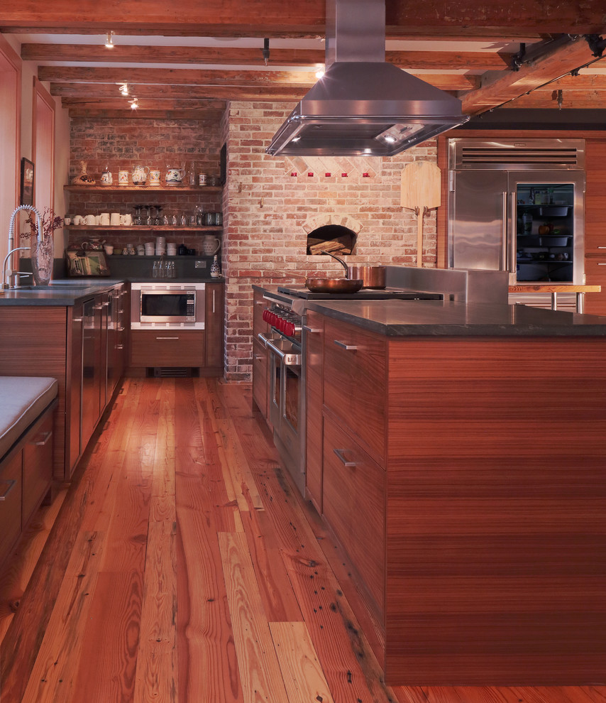 Bild på ett funkis kök, med en undermonterad diskho, släta luckor, skåp i mellenmörkt trä, bänkskiva i kvarts, svart stänkskydd, rostfria vitvaror, mellanmörkt trägolv och flera köksöar